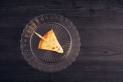 Baked cheesecake with red jam in glass plate
