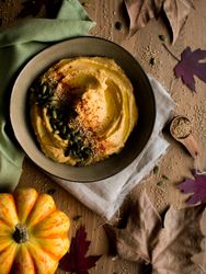 Dried leaves and napkins near pumpkin hummus