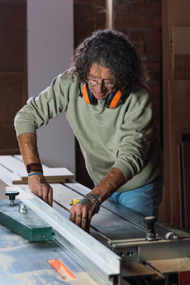 Carpenter cutting wood with circular saw in joinery