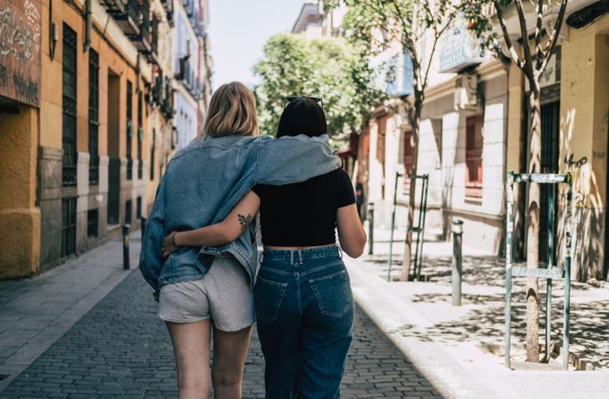 Lesbian couple hugging each other walking on street