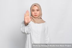 Stern Asian female in headscarf with hand up to stop 5pe7x4