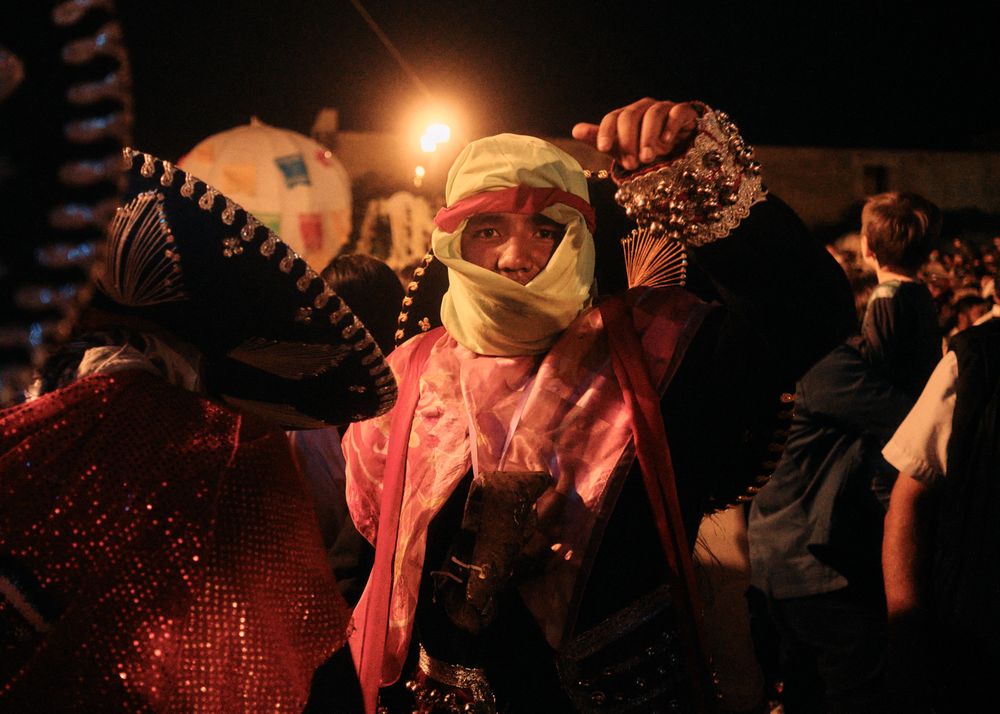 Man with face partially covered in costume for Oaxacan festival