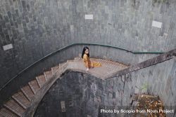 Woman in orange dress sitting on stairs 5w8e64