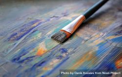 A paint brush resting on the canvas 42RZx4