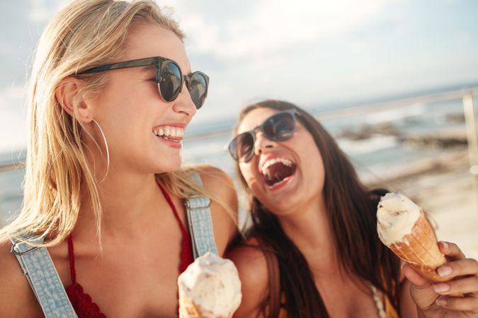Happy young female friends with ice cream enjoying together on a summer day