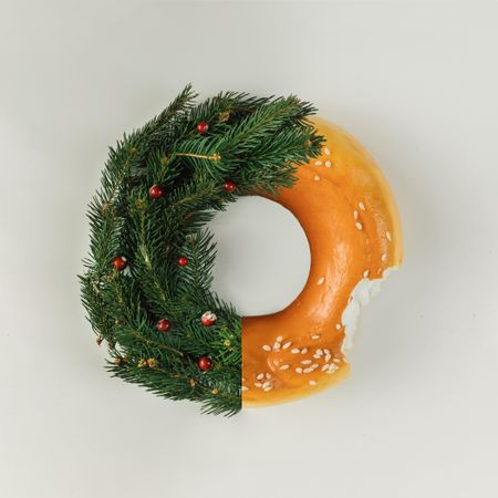 Half Christmas wreath, half bagel on light background