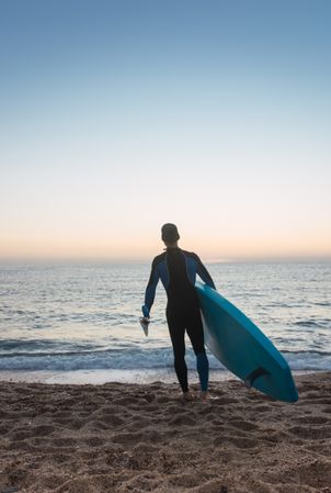 Man practicing paddle surfing with neoprene in a sunrise