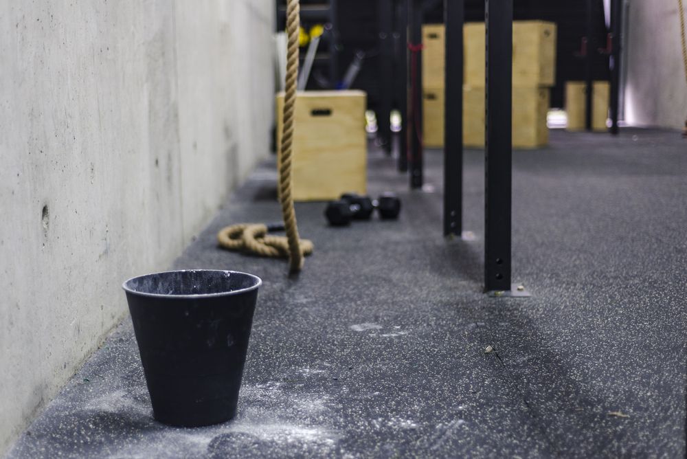 Rope near bucket of chalk in gym