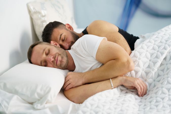 Cute male sleeping and holding each other in bed