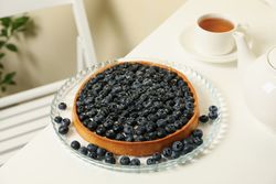 Concept of tasty breakfast with blueberry pie on table