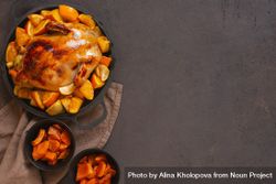 Chicken roasted in pot with oranges on table with copy space 0L2NV4