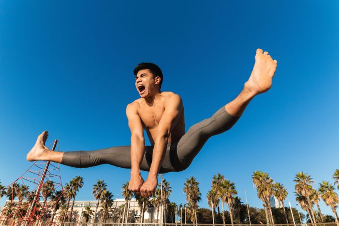 Strong man jumping high during outdoor workout