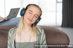 Portrait of young woman listening to music with with her eyes closed bxyOa0