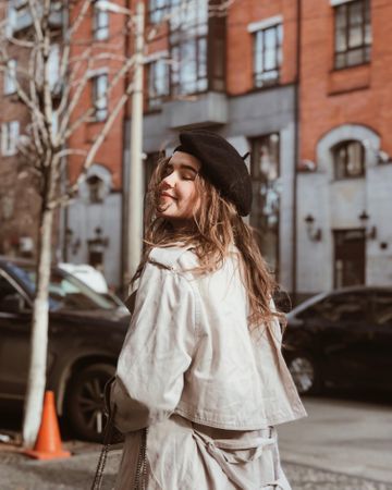 Woman wearing beret and trench coat outdoors