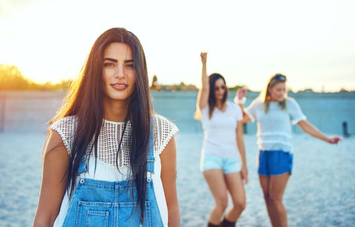 Brunette woman with friends in background on beach