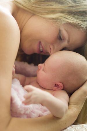 Young Mother Holding Her Tiny Newborn Baby Girl