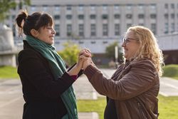Portrait of a smiling lesbian couple holding hands and looking to each other outdoors