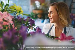 Smiling woman working at indoor plant nursery 5Qp6V0