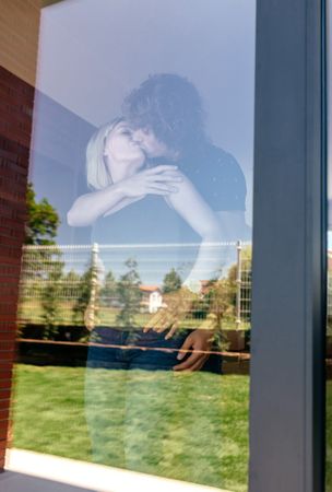 Couple kissing behind the window