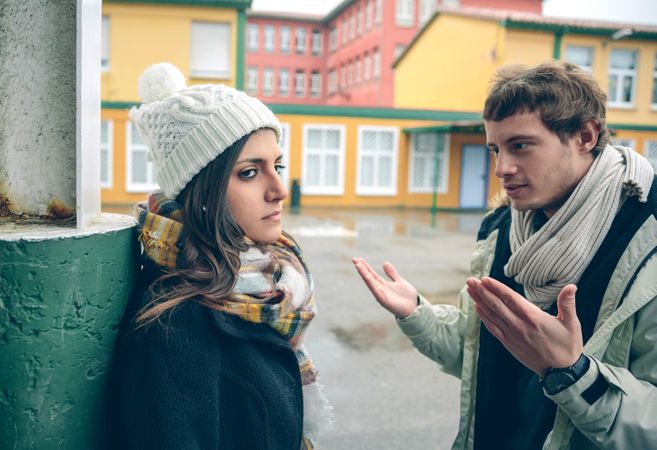 Couple in winter clothes having a disagreement outside