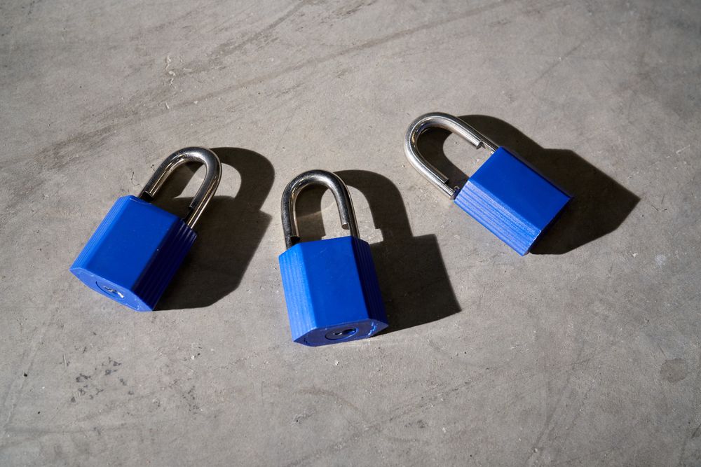 Similar blue metal padlocks placed on gray floor
