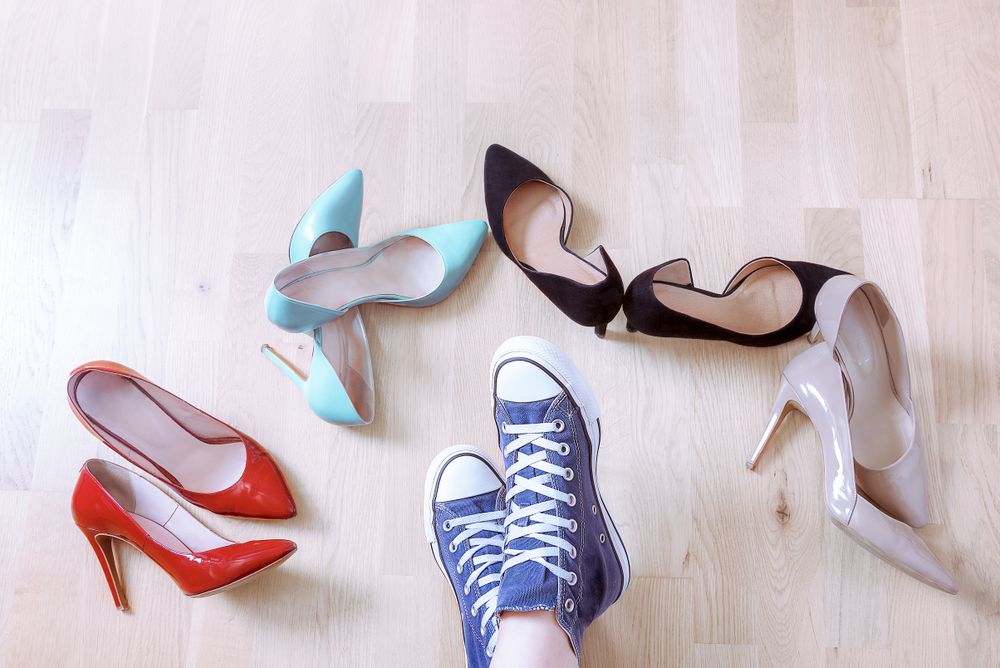 Pair of sneaker surrounded by elegant shoes