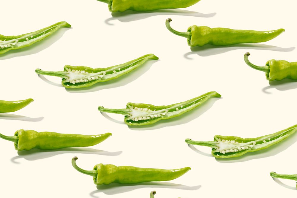 Cut green pepper among rows of whole peppers