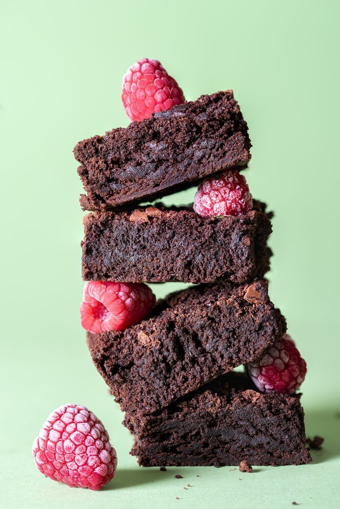 Stack of brownies and frozen raspberries
