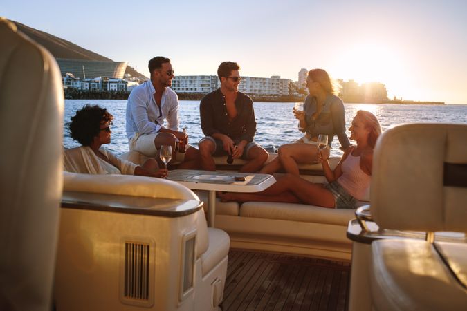Group of friends enjoying sunset on yacht