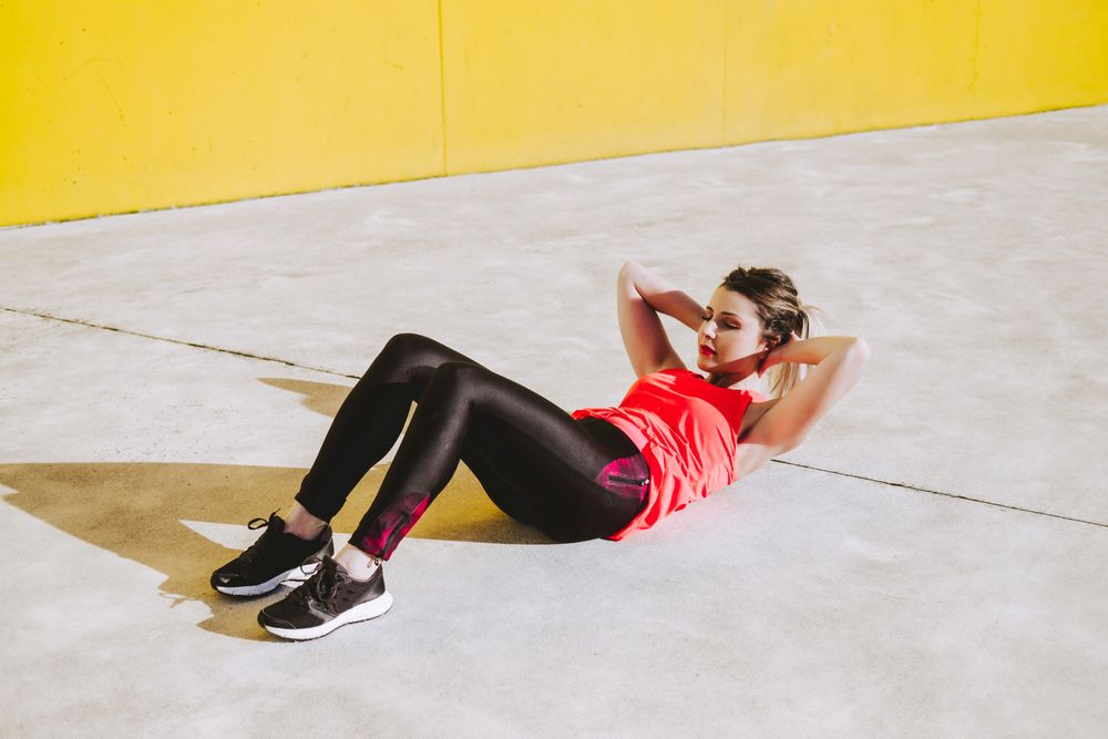 Woman doing sit ups exercises on floor
