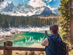 Woman in down vest taking photo of amazing landscape