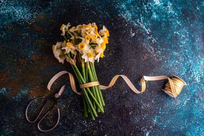 Bouquet of fresh spring daffodil flowers on blue counter