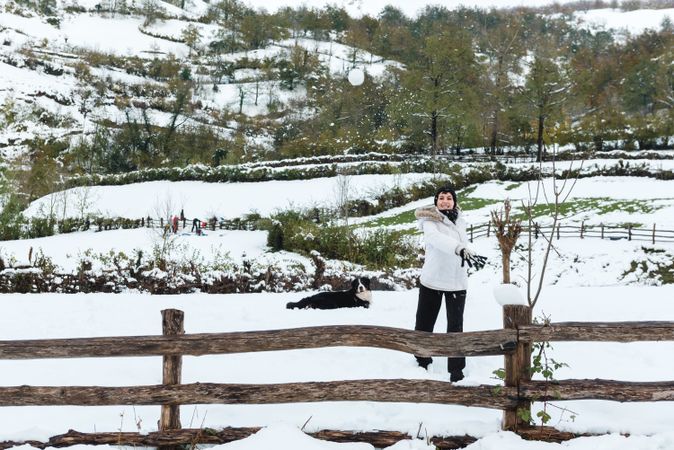 Happy woman play snowballs in countryside