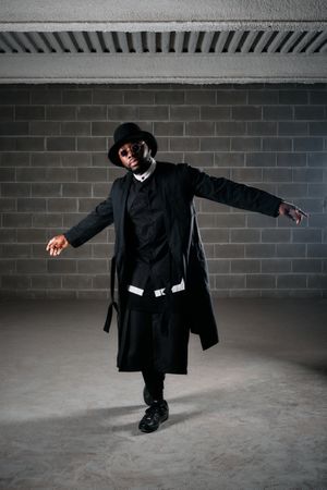 Stylish male in trendy clothes with arms apart