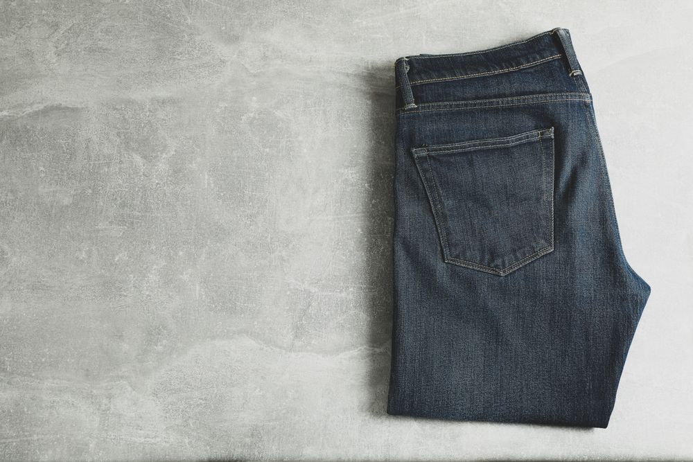 Classic jeans on grey background, space for text