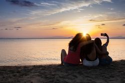 Peaceful fellows taking selfie con seashore