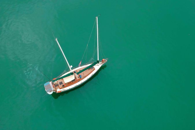 Aerial view of light and wooden sail boat on water