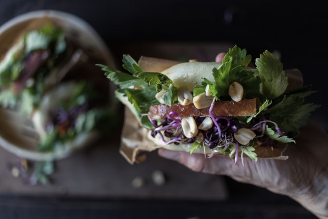 Crop person having traditional Gua Bao sandwich