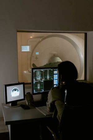 Person using computer monitor beside MRI room