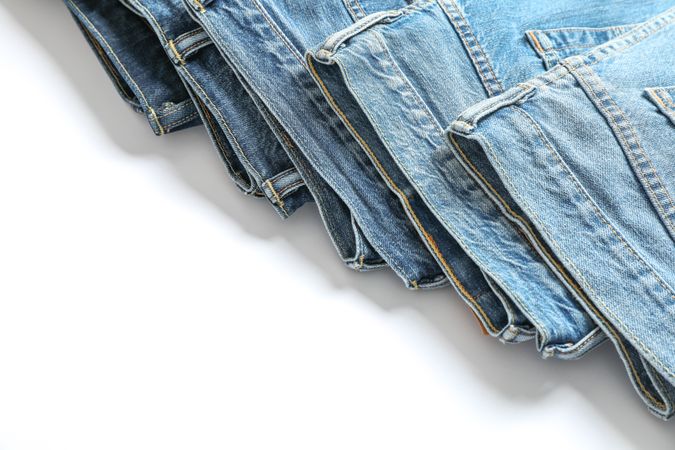 Jeans of different colors isolated on light background, space for text