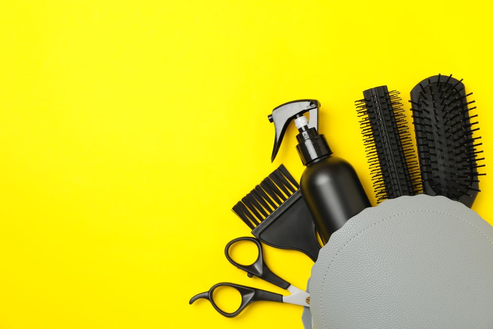 Composition with hairdresser accessories on yellow background, space for text