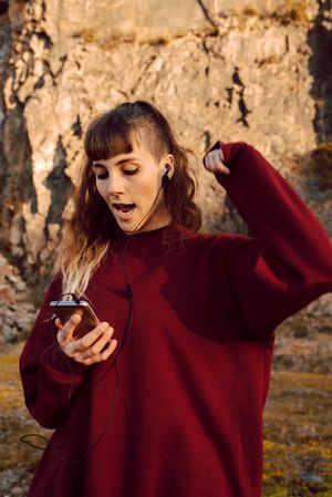 Young woman with smartphone dancing