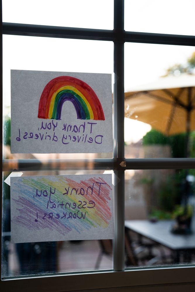 Two homemade signs from the inside of a home thanking essential workers during lockdown