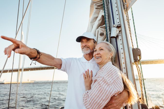 Mature man pointing into the distance and hugging his wife