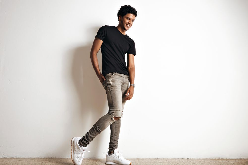 Full body shot of smiling model in plain room