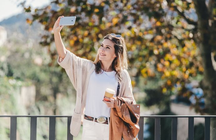 Smiling woman taking selfie in city
