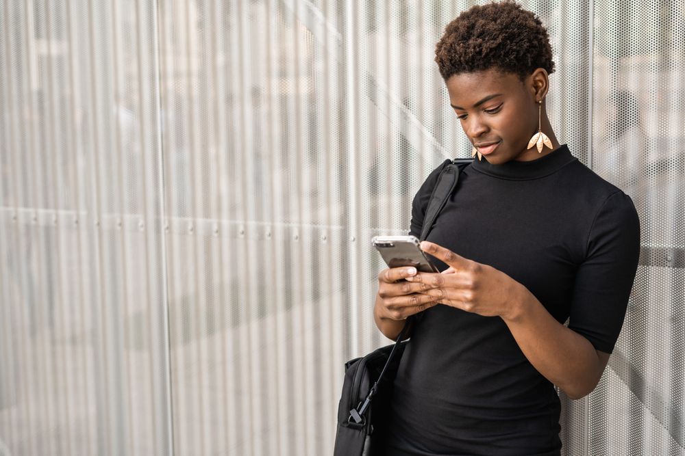 Concentrated female using mobile near urban building