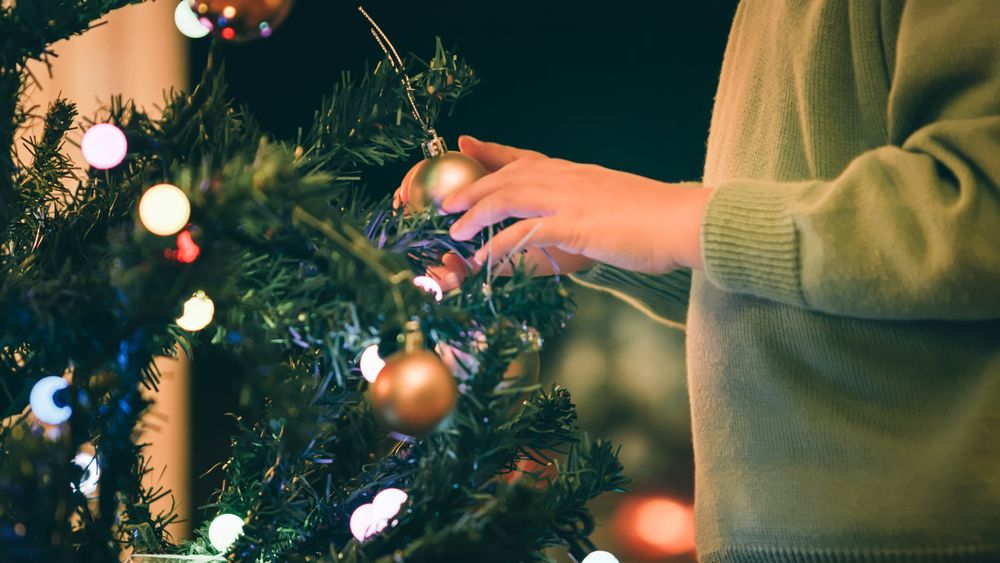 Boy decorating Christmas tree in evening