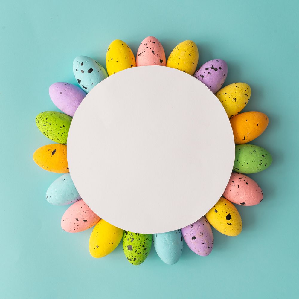 Creative composition made with colorful Easter eggs and paper card copy space