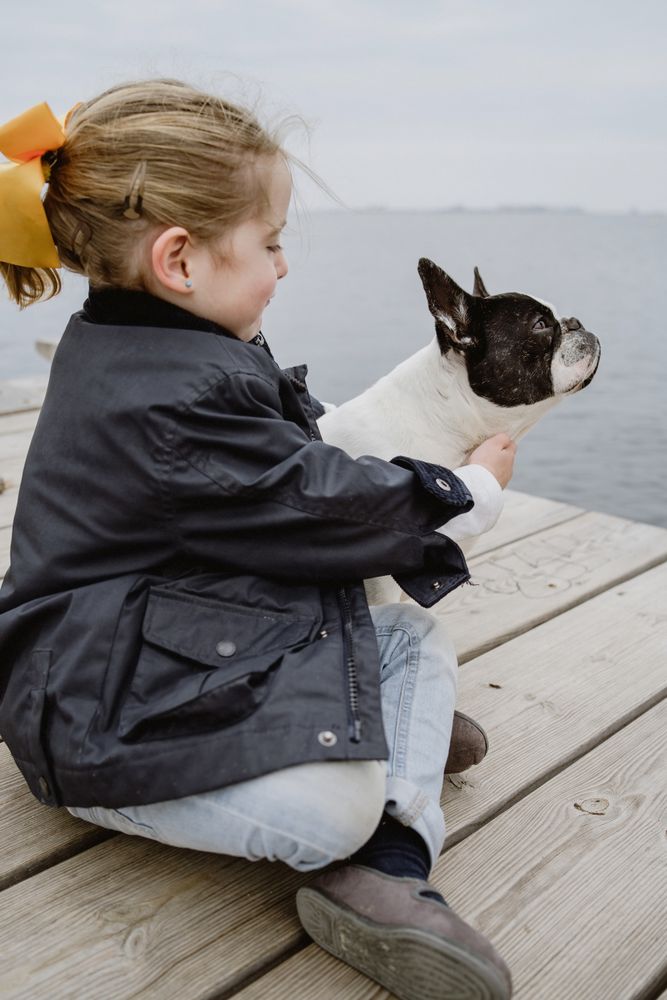 young girl with dog on pier
